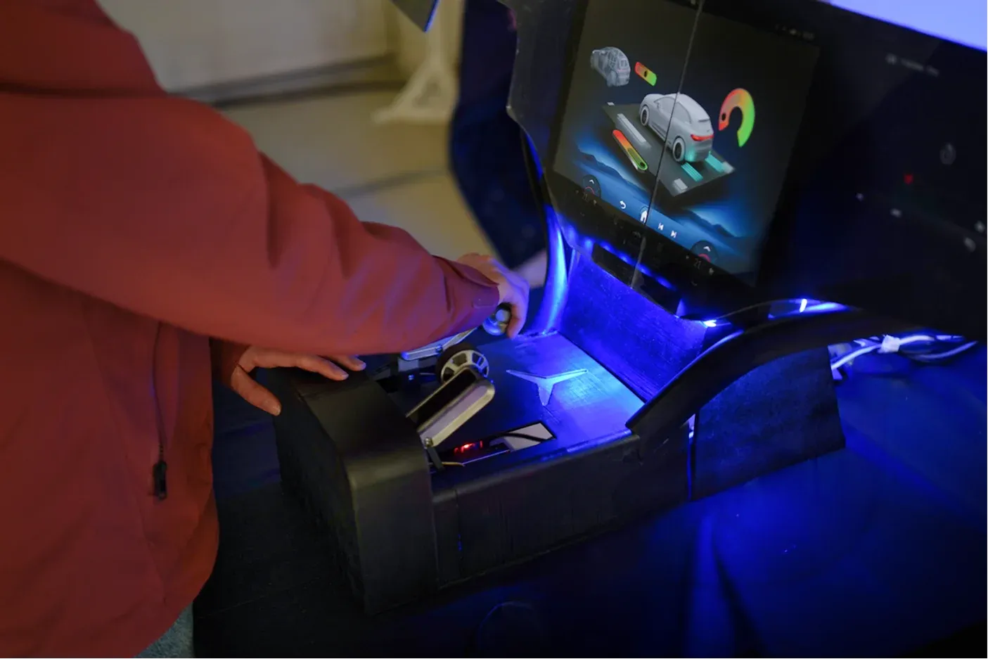 A visitor at the final presentation reaching for Glide's tangible controls, the interface lit on the display above.