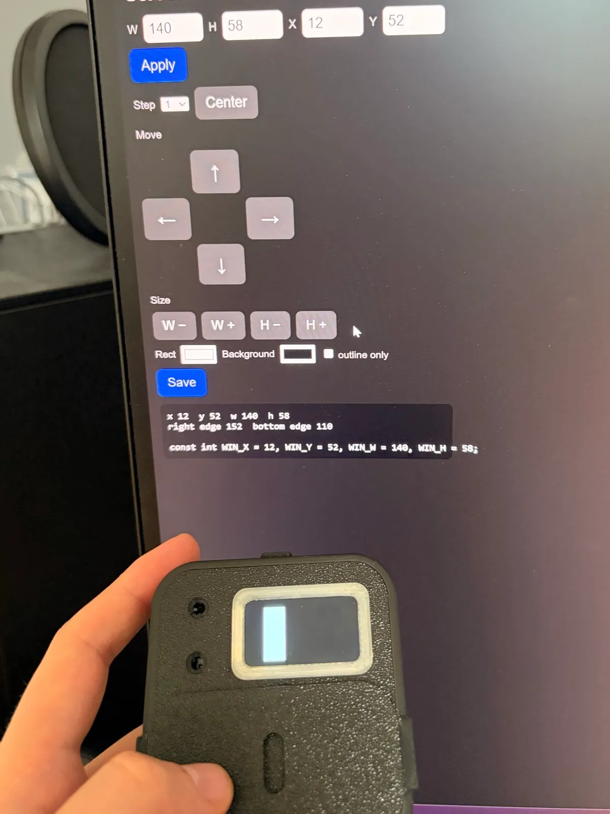 A web page on a monitor with width, height and position fields and arrow buttons, above the recorder held in a hand. A white rectangle on the recorder's screen sits inside the cutout in its cover.